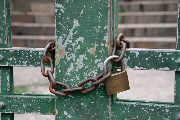 Lock with chain in green metal door at the street