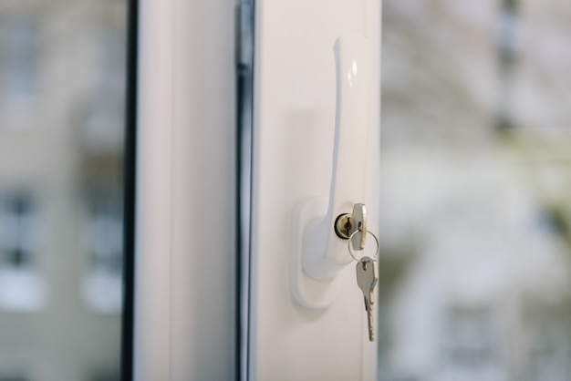 Lock with keys sticking out as safety precaution from kids or children falling out of the window