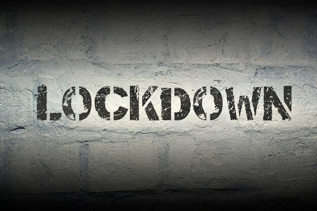 Lockdown stencildruk op de grunge witte bakstenen muur