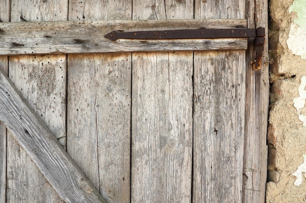 田舎の納屋のロックされた古い木のドア 木の板と錆びた鉄のステープルの質感 古代の建物の閉じたドア 放棄された忘れられた崩れかけた建物