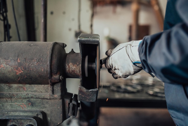 A locksmith grinding pieces of iron on a machine