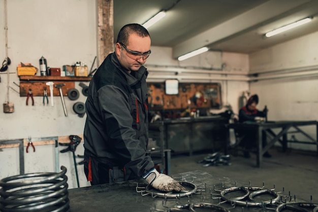 The locksmith measures the pieces of steel and preparing them for welding