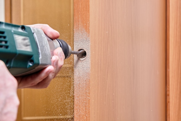 Locksmith use a flat bit to wood when drilling a hole for latch.