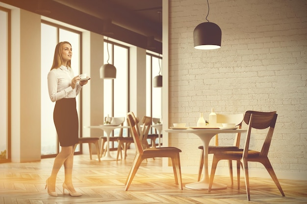 Loft restaurant corner with a wooden floor, tall windows and gray and wooden chairs near round tables. A woman 3d rendering mock up toned image