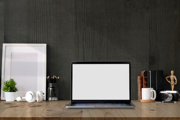 空白の画面のラップトップコンピューターとコピースペースを持つロフトワークスペースモックアップポスター。