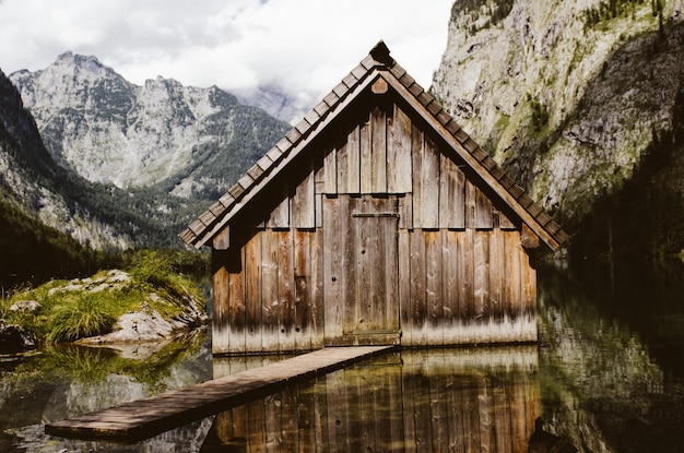 Foto cabina di legno nel lago contro le montagne