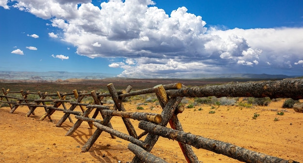 Log fence in a desert land blue sky with clouds sunny spring day in american countryside usa