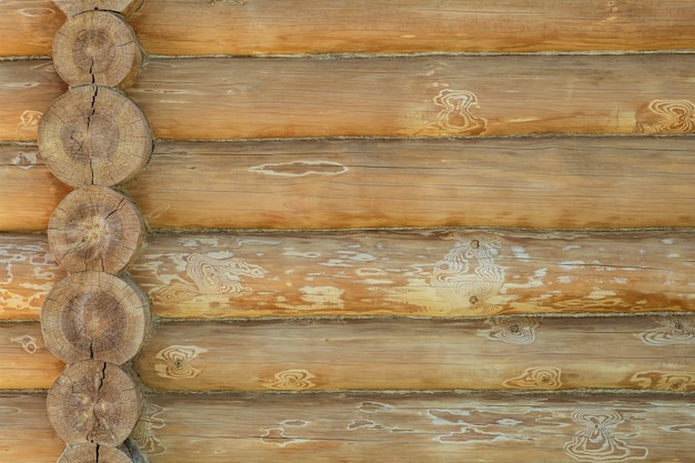 Предпосылка стены бревенчатого дома. Строительство деревянного экологичного дома из натуральных материалов. Узор и текстура деревянной кладки. Фото высокого качества
