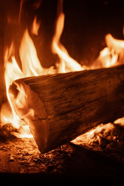 家の囲炉裏の中の暖炉で燃える薪の丸太