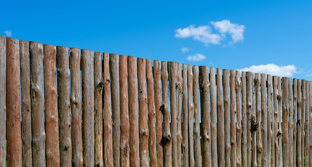 Log wooden fence. The texture of the old wooden fence. Wooden vintage background.