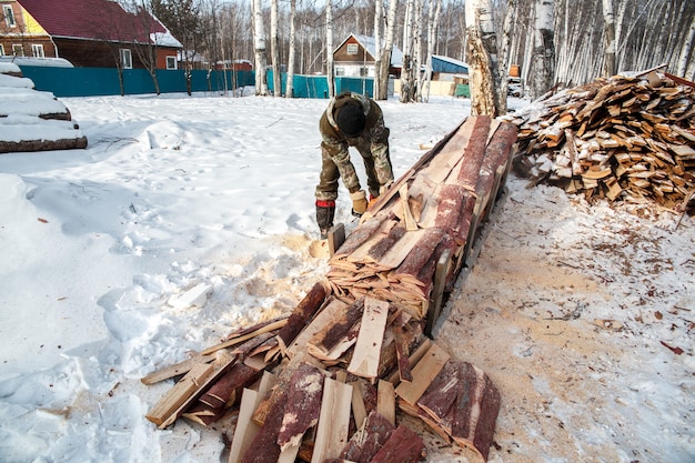 logger zaagt een boom in het bos in de winter, Rusland voor brandhout