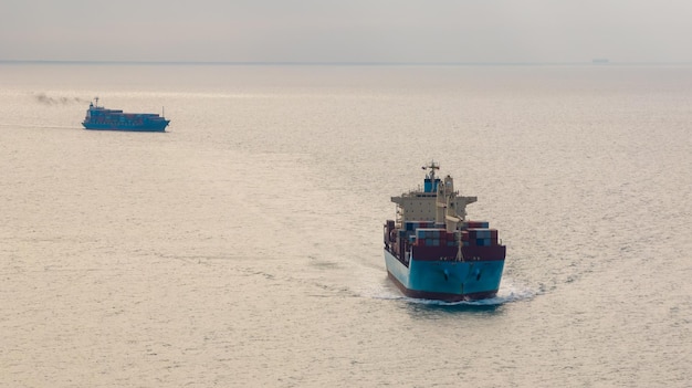 Фото Логистическое грузовое контейнерное судно, плавающее в море для импорта и экспорта товаров