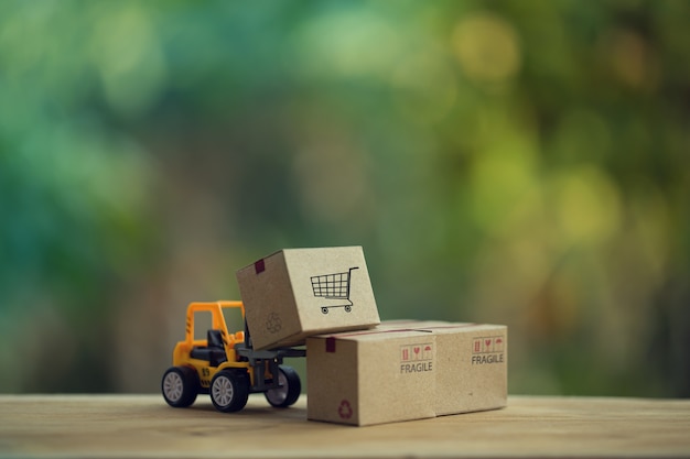 Logistic and cargo freight concept: Fork-lift truck moves a pallet with Paper boxes.