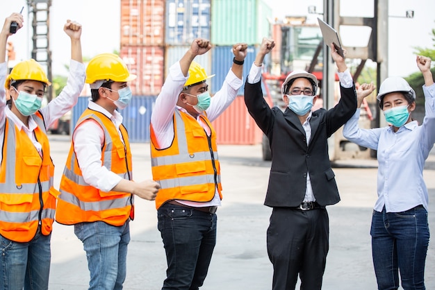 Logistic team worker celebrating of successful work at container warehouse or construction site