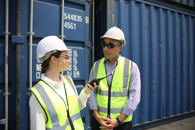 Controllo dell'ingegnere logistico al porto, carico di container per l'esportazione di camion e importazione del concetto logistico