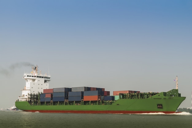 Logistics and transportation Container Cargo ship with tugboat in the ocean