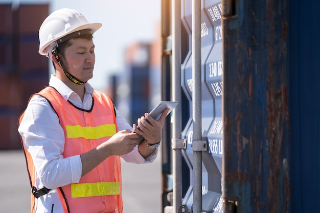 Logistiek engineer controle in de haven, containers laden voor vrachtwagens exporteren en logistiek importeren