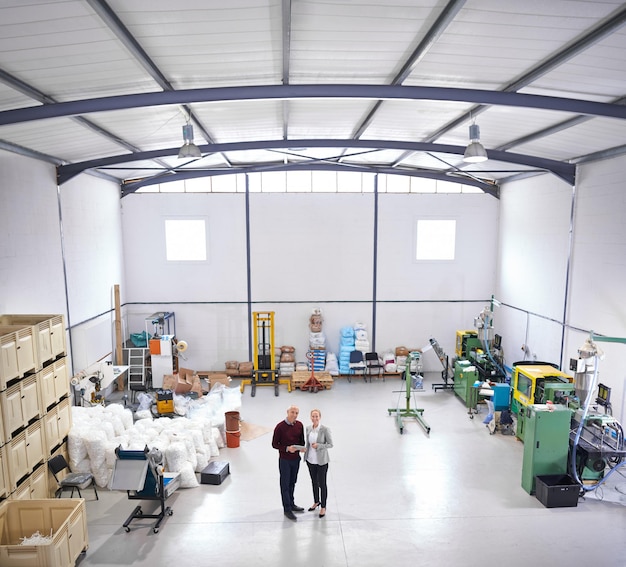 Foto logistiek magazijn en portret van zakenlieden met tablet voor partnerschapsopleiding en -management volwassen man vrouw en fabriek met techniek voor teamwerk lading of distributie van boven