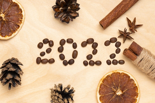 갈색 나무 배경에 커피 콩과 향신료의 로고 2022. 2022년 새해 복 많이 받으세요