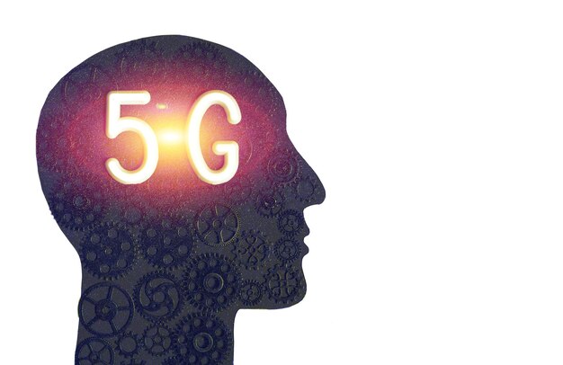 Логотип сетей 5G в силуэте человеческой головы на фоне шестеренок. Понятие прогресса.