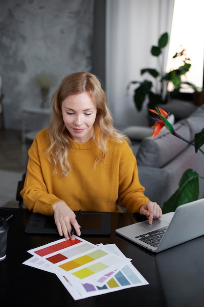 Photo logo designer working on her tablet connected to a laptop