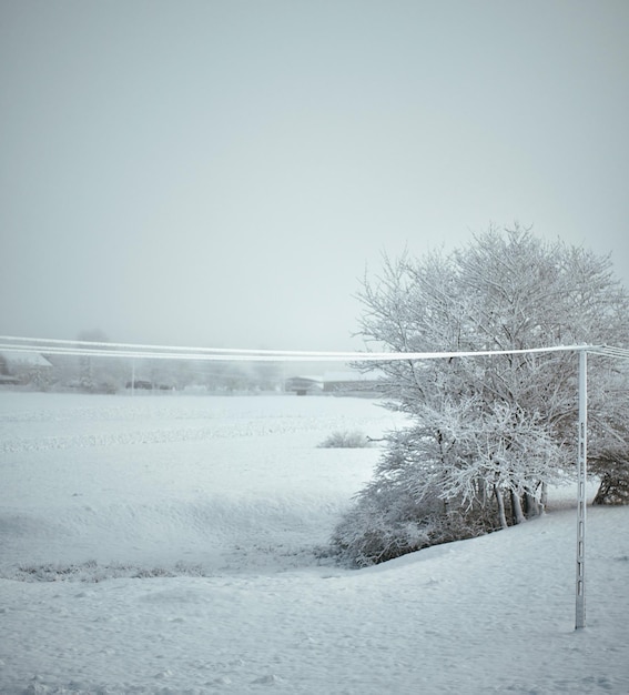 Lokale elektrische paal bedekt met ijs en sneeuw Concept van elektriciteits- en stroomuitvalprobleem tijdens sneeuwstormen in de winter op het platteland