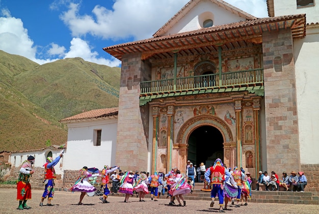 Lokale mensen vieren voor de kerk van san pedro apostol de andahuaylillas, cusco, peru