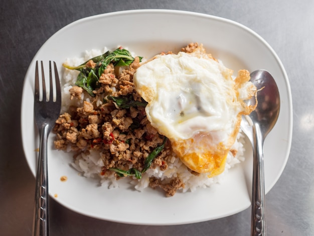 Lokale straatvoedsel Thaise rijst gegarneerd met geroerbakte varkensvlees basilicum en gebakken ei.