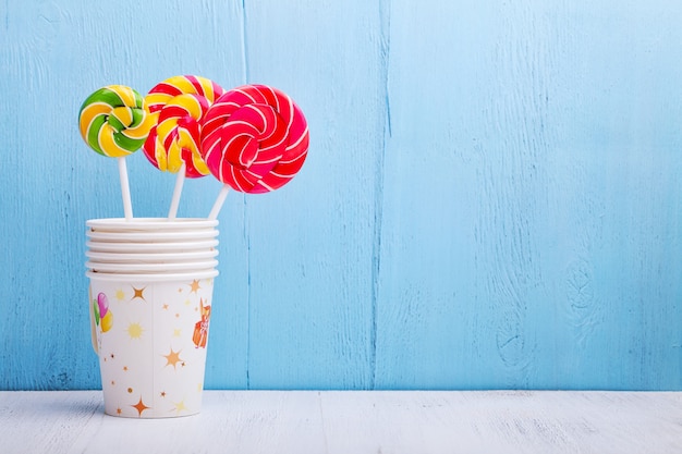 Lollies in cups op blauwe houten muur