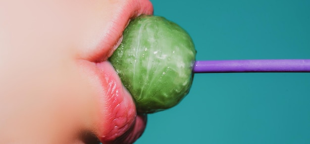 Lollipop in de mond close-up Mooi meisje mond met lolly pop Glanzende rode vrouw lippen Mond likken zuigen chupa chups