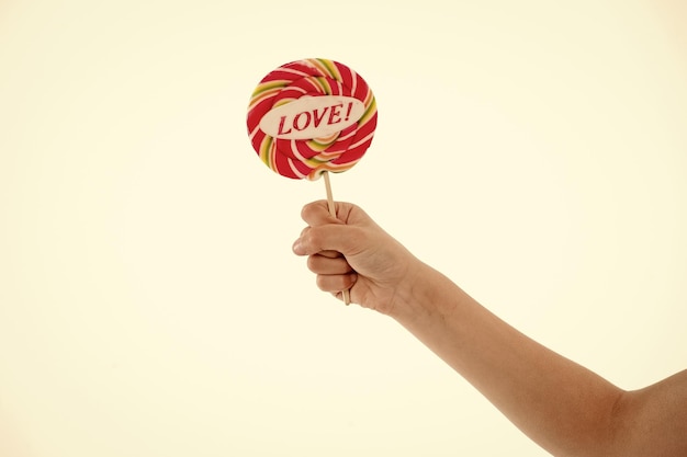 Lollipop met liefde belettering geïsoleerd op wit Snoep op stok in de hand Zoete snoep swirl Valentijnsdag concept Eten en dessert eten kopie ruimte Lollipop plezier