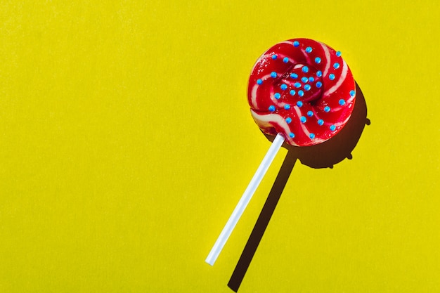 Photo lollipop on a stick isolated on yellow