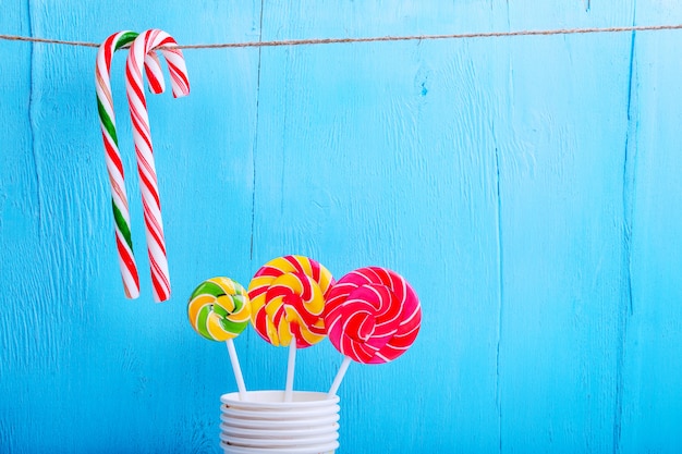 Lollipops in a cup and candy canes hanging on a thread