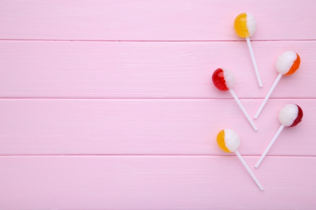 Photo lollipops on pink table. sweet candy concept