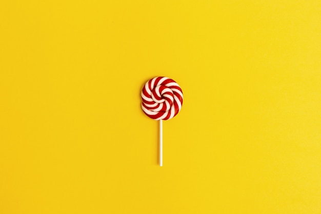 Lollypop sweet caramel candy red colored on stick. Bright background for postcard, or invitation for Birthday, party, Hen-party.