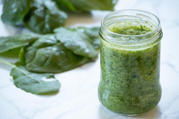 Lommerrijke groene superfood smoothie op witte achtergrond met kopie ruimte