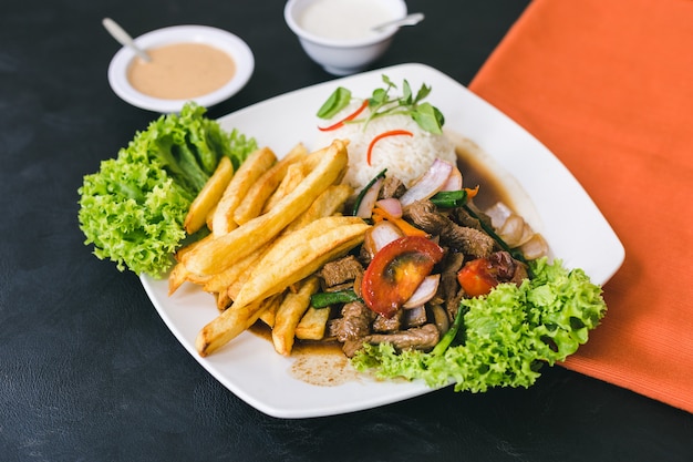 Foto lomo saltado con salsa peruviana e salsa all'aglio