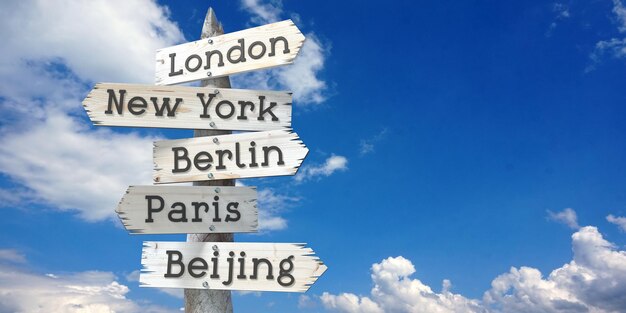 Foto londen new york berlijn parijs peking houten wegwijzer met vijf pijlen