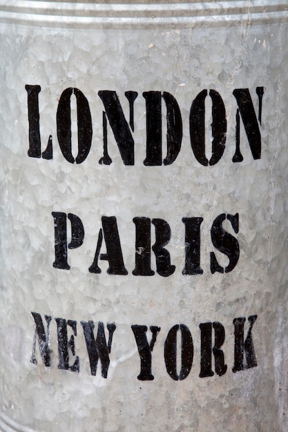 Photo london paris and new york names on metal background