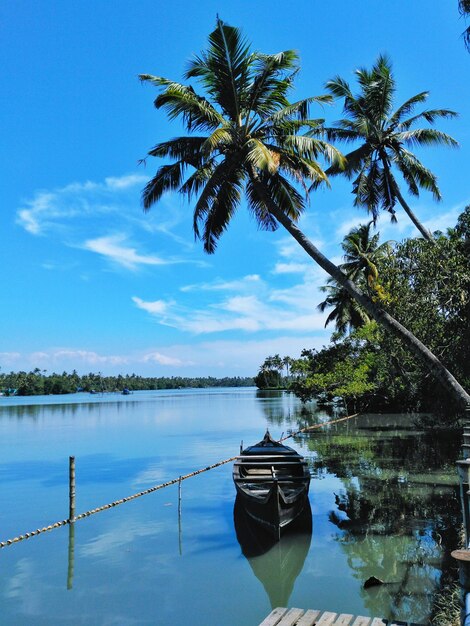 Lone boat in calm lake against blue sky