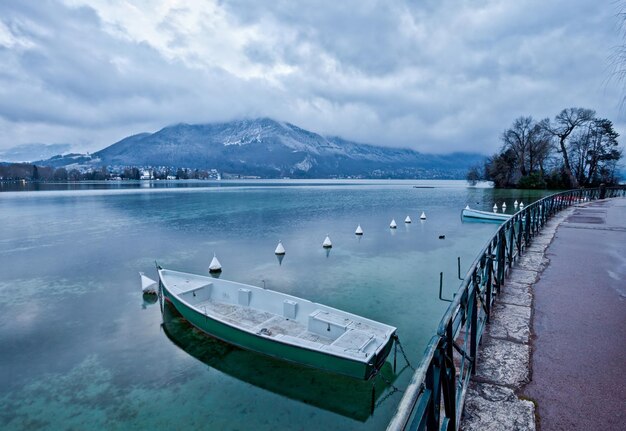 Foto una barca sola ormeggiata in un lago tranquillo