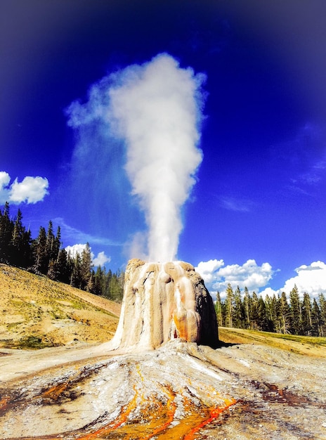 Photo lone star geyser against blue sky at yellowstone national park