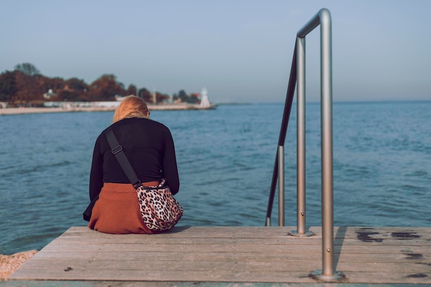 Lone woman at the pier wooden steps vintage style