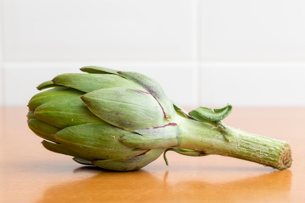 Lonely artichoke on wooden table