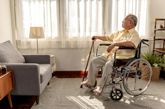 Lonely Asian Senior man was sick and sitting on wheelchair. Retirement age lifestyle and stay at home alone.