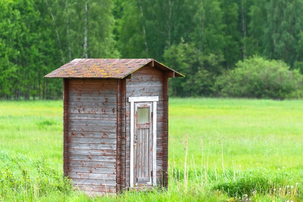 Foto fienile solitario in campo verde e foresta