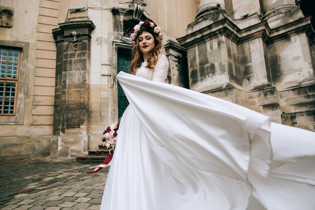 Lonely beautiful bride in a white dress walking in old city wedding concept