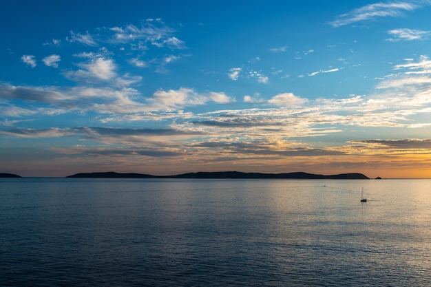 Foto una barca solitaria si allontana dall'isola di ons nella ria de pontevedra in galizia durante il tramonto