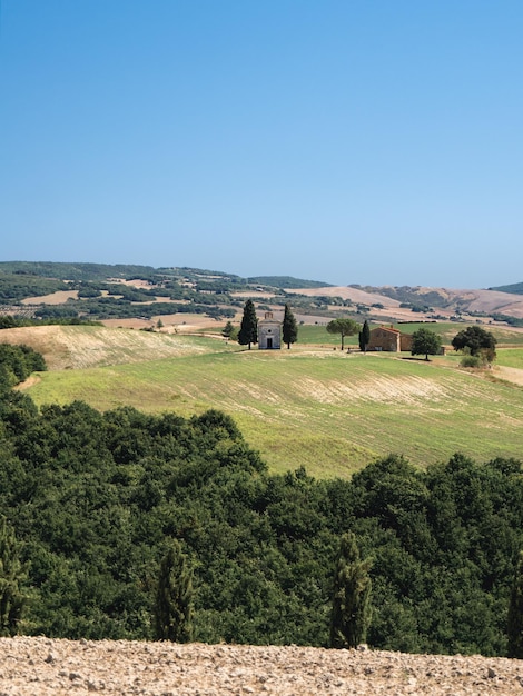 Photo lonely chapel on a green hill in tuscany