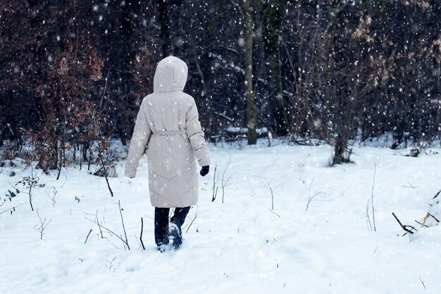 외로운 소녀는 강설량 동안 겨울에 공원에서 산책